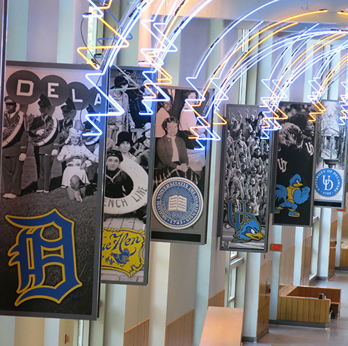 Large indoor banners depicting scenes from the University of Delaware's history.