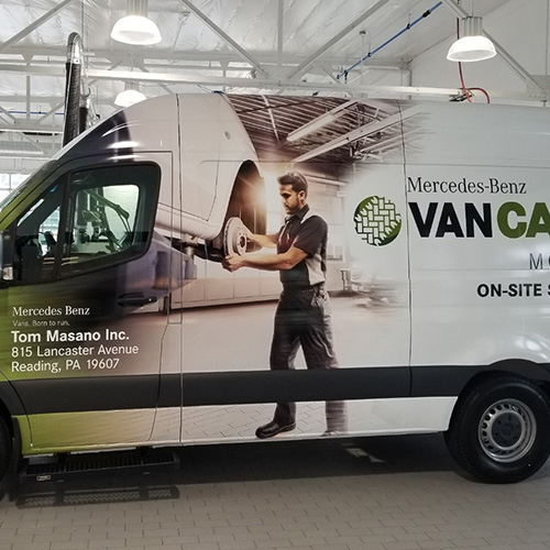 Small technician van with a vehicle wrap.